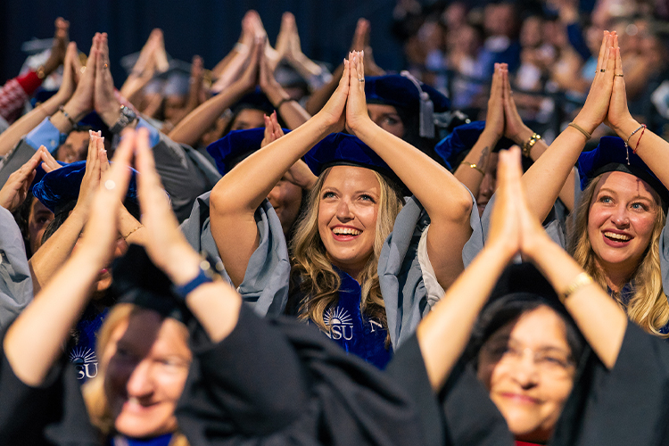 NSU graduates posing with shark fins during ceremony