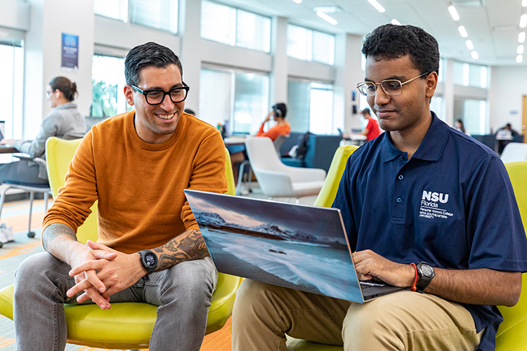 NSU student and man working together on a laptop