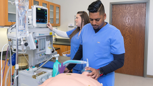 Denver medicine student doing demonstration with scrubs
