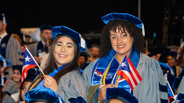 NSU puerto rican gradutes at commencement holding country flag