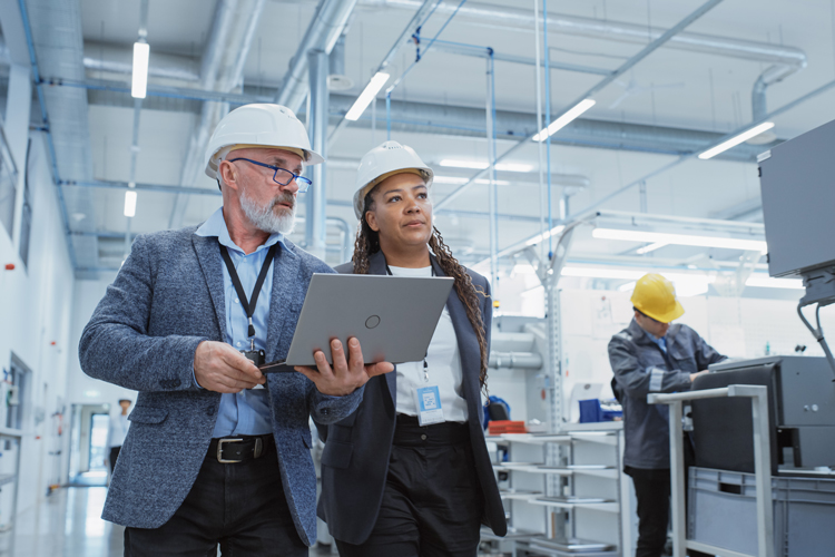 Two professional computer engineers working at factory technology with laptop