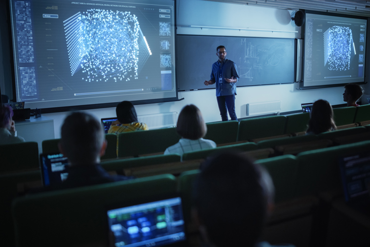 University professor explaining the importance of artificial intelligence to students in auditorium