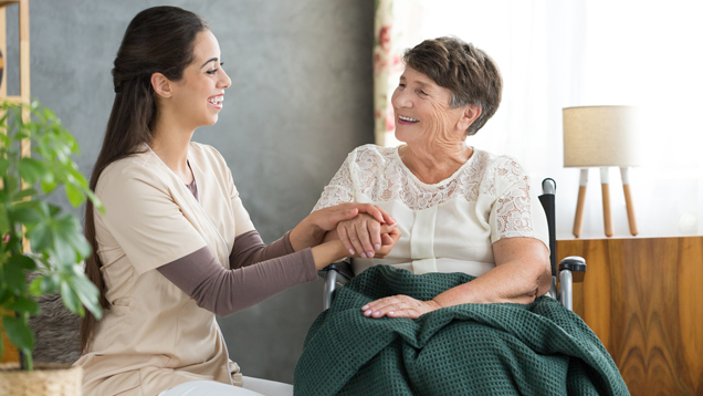 Caregiver assisting senior woman in wheelchair