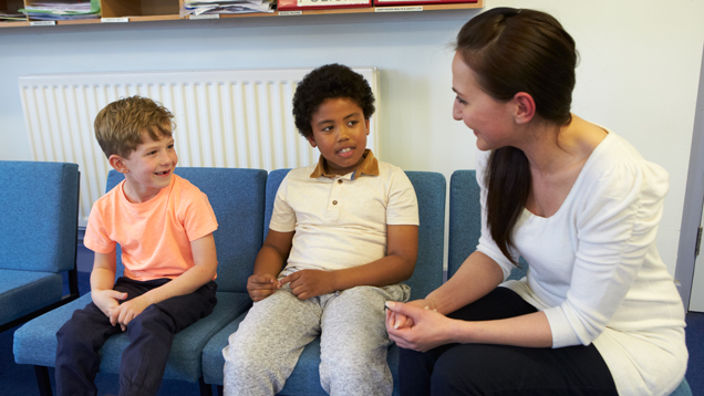 Child protection specialist speaking with kids at school office