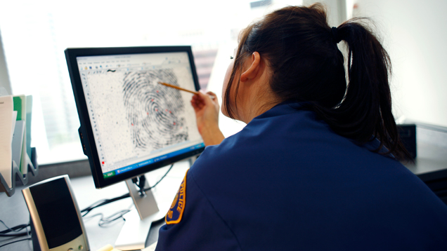 Criminal justice officer viewing fingerprints on screen