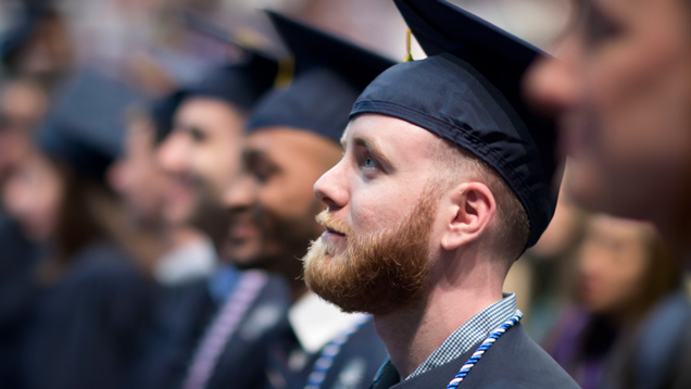 Graduate at commencement with cap and gown closeup