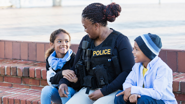 Policewoman in the community sitting with two children