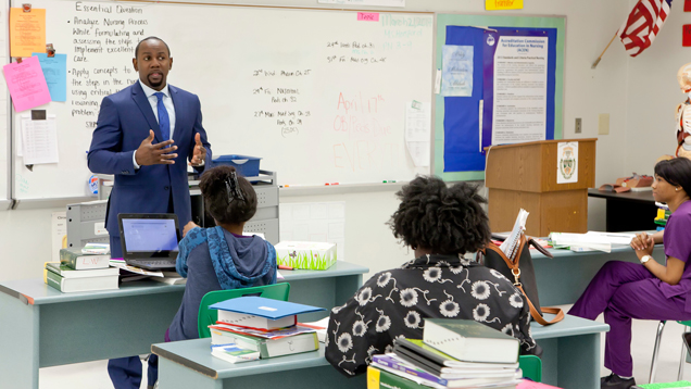 Teacher giving lecture to class gesturing with hands and speaking