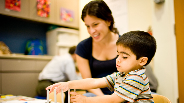 Teacher observing child with learning toys