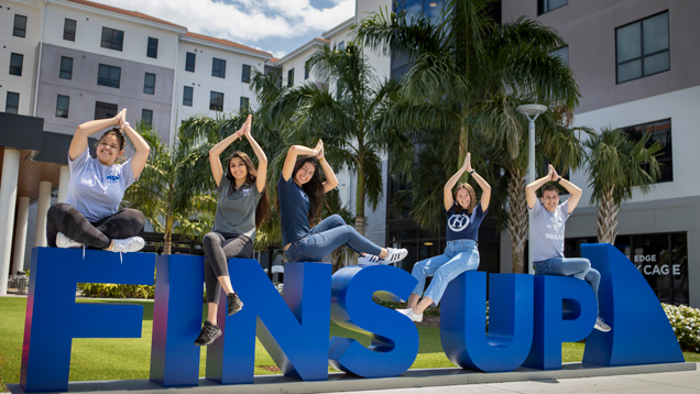 Group of students on mako hall doing fins up