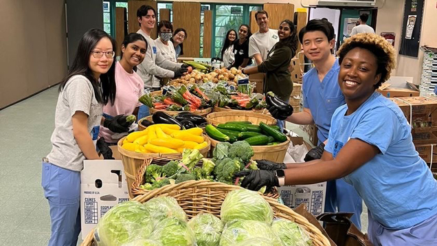 Students volunteering at community event sorting food for donations