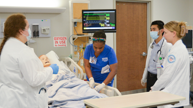 MD students learning in sim lab with dummy