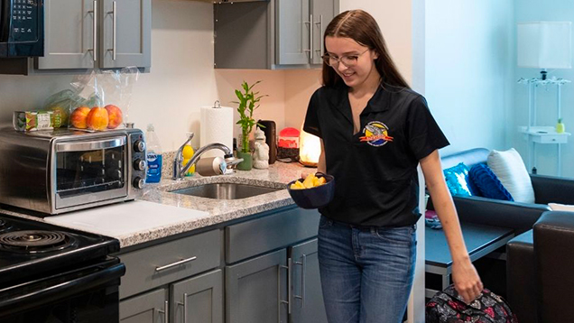 NSU student getting food in her kitchen