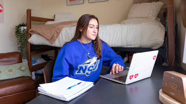 NSU student using a laptop in her room