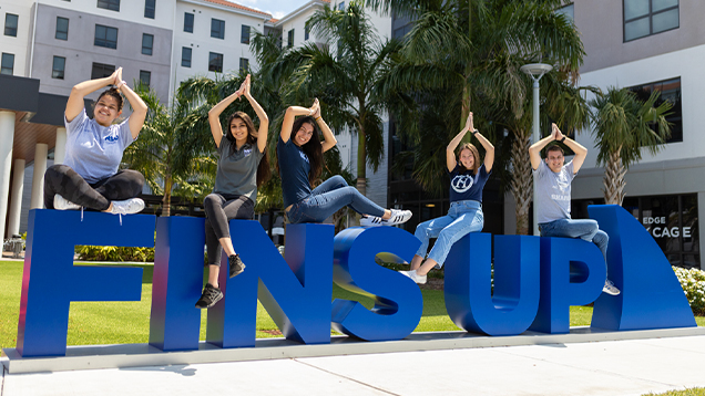 NSU students posing for a picture on the Fins Up sign