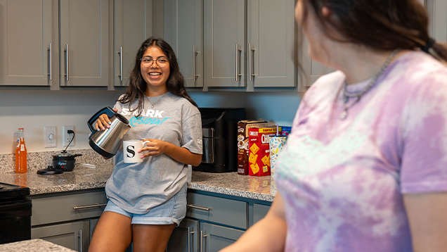 Two NSU students talking in the kitchen