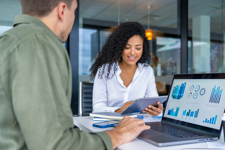 Team reviewing charts and graphs on a laptop