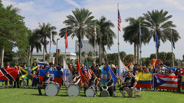 Group of NSU students holding international flags outdoors