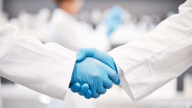 Healthcare people shaking hands with gloves symbol of collaboration