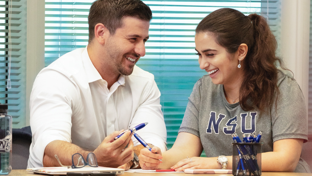 Laughing career professional development student and coach sitting on desk