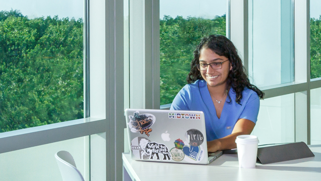 Student using laptop sitting on desk