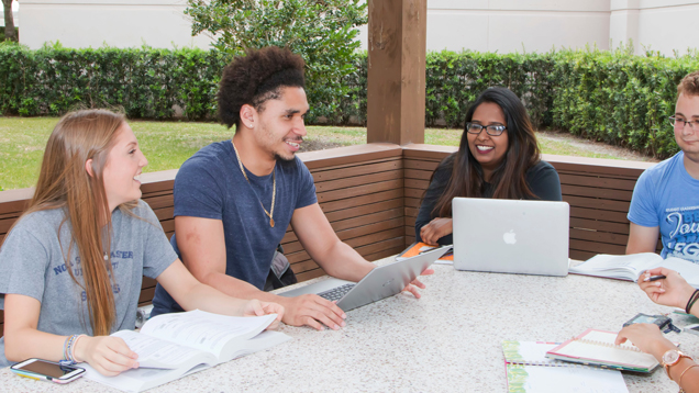 Students gathered speaking on table