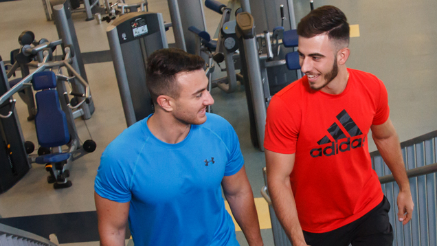 Two NSU sharks at the gym going up the stairs