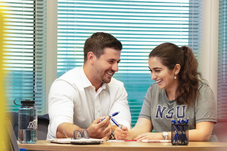 Laughing career professional development student and coach sitting on desk