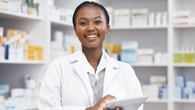 Woman in pharmacy with tablet smiling