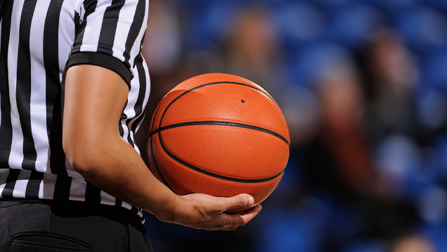 Basketball referee holds a ball during a game