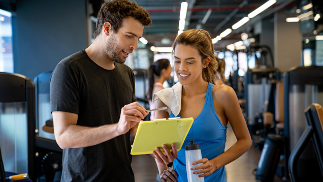 Trainer at the gym reading exercise policies and procedures