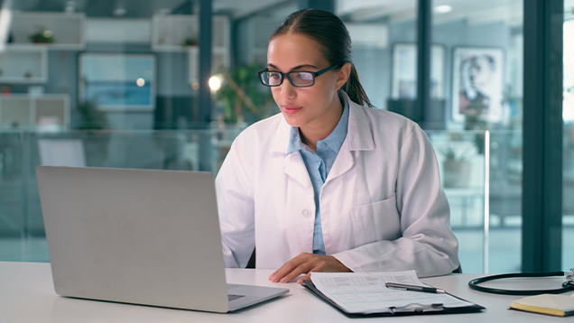 Doctor reading information on a laptop in an office