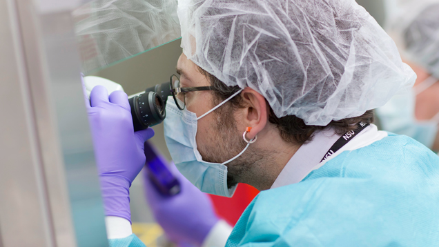 Person conducting a research using microscope