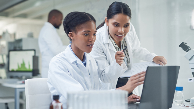 Two scientists looking at a laptop in a lab