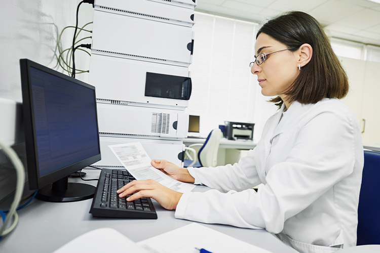 Scientist using a computer while looking at a document