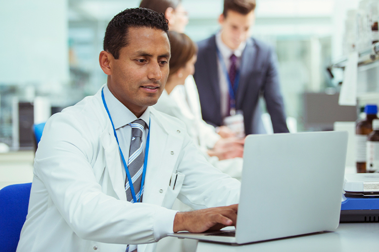 Scientist using laptop in laboratory