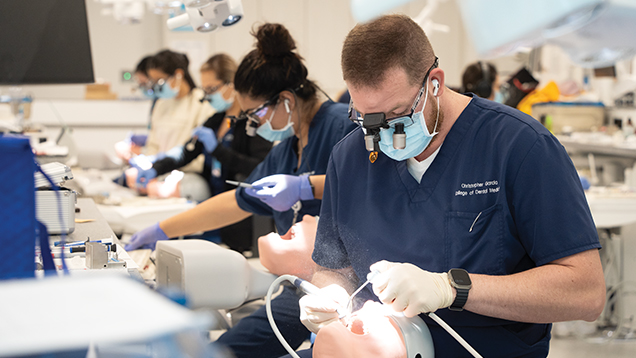 Group of dentists practicing medical procedures on dental manikins