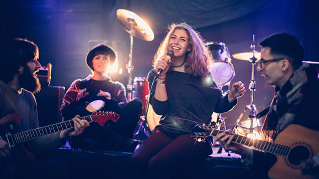 Musical band sitting on stage and having rehearsal