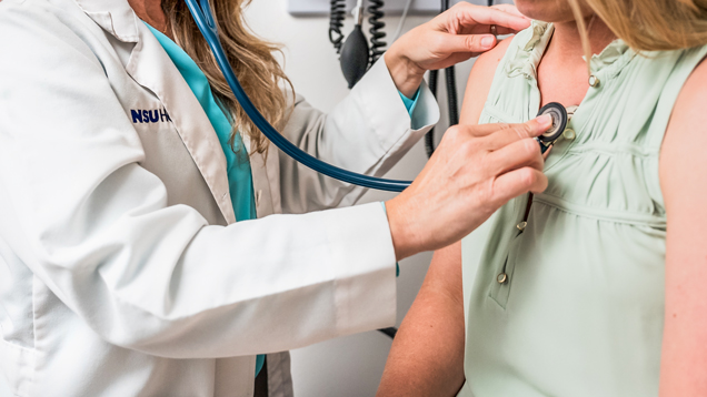 NSU health doctor using stethoscope on student chest