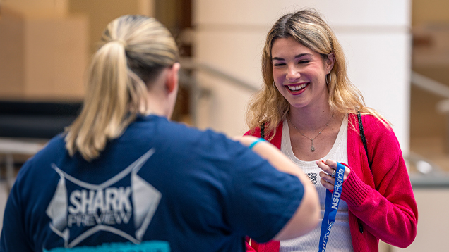 NSU student speaking to a woman during shark preview event