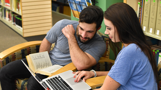 NSU students using a laptop at the library