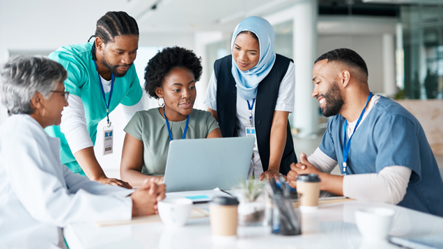 Team meeting with doctors looking at laptop