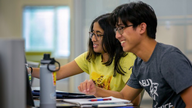 Two young students on computer enrolling