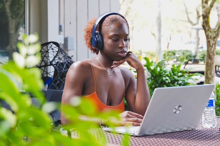 NSU student using computer on outdoor