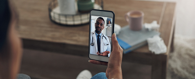 Shot of an unrecognizable person on a video call with a doctor